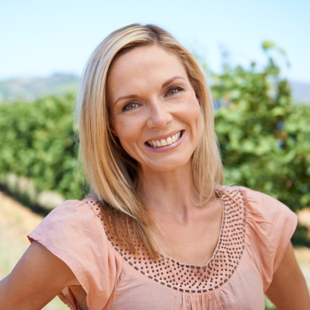 At home in the vineyard. Portrait of a mature woman enjoying a day in the vineyards.